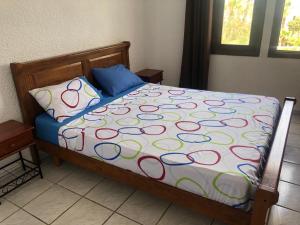 a bed with a colorful comforter and a pillow at Bahia Smir in Tétouan
