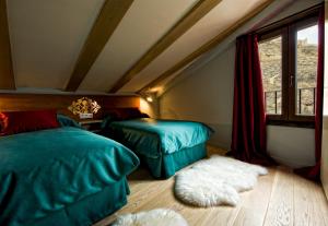 a bedroom with two beds and a window at Hotel Albanuracín in Albarracín