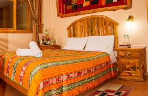 a bedroom with a bed with two towels on it at Hotel Santafe Inn in Otavalo