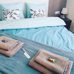 a bed with towels and a thermometer on it at Dream LUX Apartments in Kraków