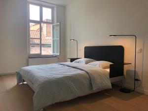 Schlafzimmer mit einem Bett und einem Fenster in der Unterkunft Bed & Boon in Gent
