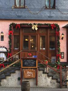 ein Haus mit Weihnachtsdekoration und einem Schild davor in der Unterkunft Das Loreley Weinstuebchen in Sankt Goarshausen