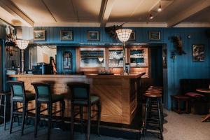 a bar in a restaurant with blue walls and stools at Vågslidtun Hotel in Vågsli
