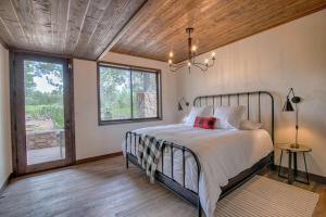 a bedroom with a bed and a large window at The Cabin Home in Show Low