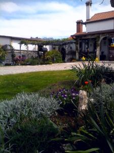 a garden in front of a house with flowers at Haus Randelj in Labin