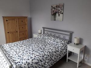- une chambre avec un lit et une couette noire et blanche dans l'établissement Old Orchard Bed & Breakfast, à Froggatt