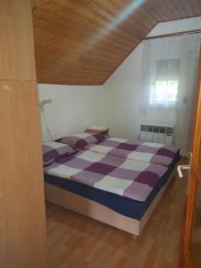 una camera con letto viola e bianco e finestra di Gold Apartment a Harkány