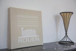 a book sitting on a table next to a vase at CosyRouen Gare in Rouen