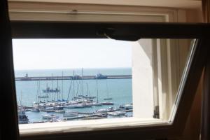 a window with a view of a harbor with boats at La Dolce Vista - B&B di Charme in Manfredonia