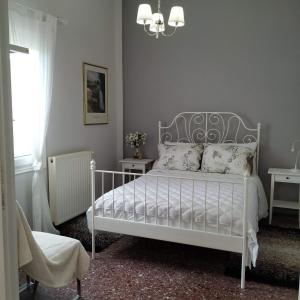 卡尼亞鎮的住宿－Sunday Apartment Chania 2A，卧室配有带枕头和吊灯的白色床。