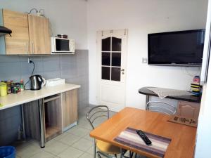a small kitchen with a table and a tv on the wall at Kwatery w Gołdapi in Gołdap