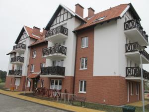 a building with balconies on the side of a street at Apartament Mierzeja in Sztutowo