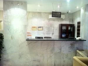 a waiting room with a counter and a sign on the wall at Makarim Najd Apartments 3 in Riyadh