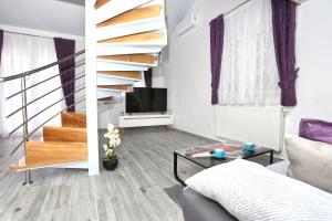 een woonkamer met een trap en een tv bij Apartman Kristian in Trogir