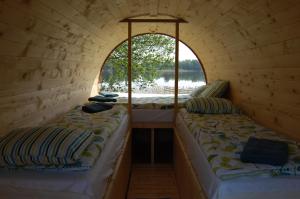 two beds in a small room with a window at Ezermala in Valdemārpils