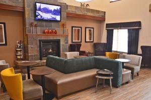 een woonkamer met een bank en een open haard bij Best Western Plus Gateway Inn & Suites - Aurora in Aurora