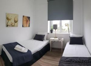 a bedroom with two beds and a table with a lamp at Seaside Maisonette House in Artemida