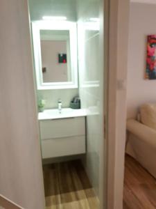 a bathroom with a white sink and a mirror at Seaside Maisonette House in Artemida