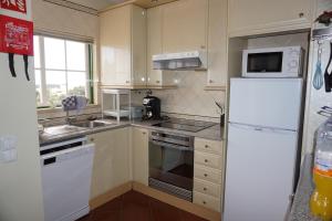 a kitchen with white appliances and a white refrigerator at Vau Seaview Apartment in Portimão +92 photos