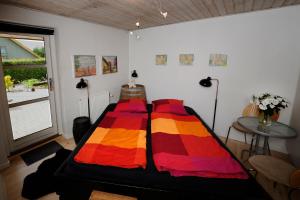 Una habitación con una cama con una manta de colores. en Bed & Breakfast Horsens - Udsigten, en Horsens