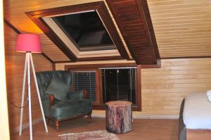 a bedroom with a tv and a chair and a lamp at 61 Dilek Pansiyon in Uzungöl +18 photos