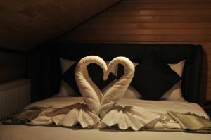 two swans making a heart on a bed at 61 Dilek Pansiyon in Uzungöl