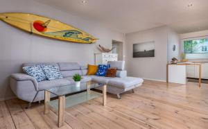 a living room with a couch and a surfboard on the wall at Surf Villa in Łeba