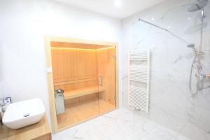 La salle de bains est pourvue d'une douche, de toilettes et d'un lavabo. dans l'établissement Zollikof Aparts - Sauna & Studioapartments, à Leipzig