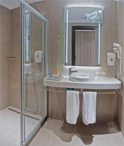 uma casa de banho com um lavatório e um chuveiro em Ostimpark Business Hotel em Ancara