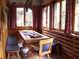 a room with a wooden table and chairs and windows at Arche de Noé B&B in Verbier