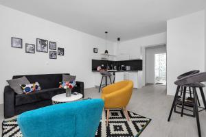 a living room with a black couch and yellow chairs at Apartments Morpheus in Makarska