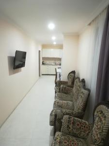 uma sala de estar com duas cadeiras e uma televisão em West House em Kobuleti