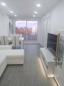a living room with white furniture and a large window at Luxury CAP SALOU with POOL & BARBECUE & WIFI in Salou