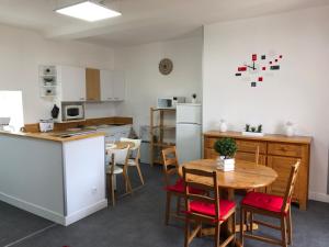 a kitchen and dining room with a table and chairs at APPT 1.5KM PLAGES DU DÉBARQUEMENT in Tracy-sur-Mer