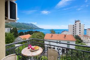 a balcony with a table with a bowl of fruit on it at Vila Hortenzija in Becici