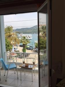 balcón con mesa, sillas y vistas al agua en Hotel Papasotiriou en Galatas