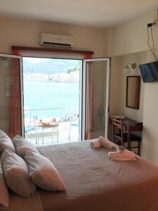 a bedroom with a large bed with a view of the ocean at Hotel Papasotiriou in Galatas
