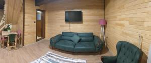 a living room with a couch and a tv on a wall at 61 Dilek Pansiyon in Uzungöl