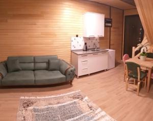 a living room with a couch and a kitchen at 61 Dilek Pansiyon in Uzungöl