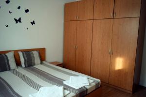 ブルガスにあるSea Gardenのベッドルーム1室(壁に木製キャビネットとコウモリが付いたベッド1台付)