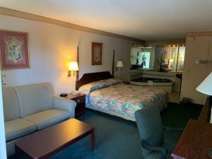 a hotel room with a bed and a couch at Executive Inn Yanceyville in Yanceyville