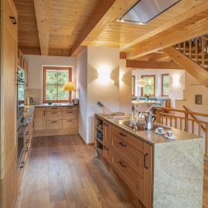 a large kitchen with wooden floors and a wooden ceiling at Villa Ruah in Weissensee