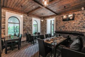 un restaurante con techos de madera, mesas y sillas en Musson Hotel, en Yalta