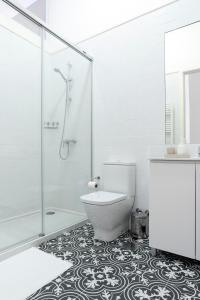 La salle de bains est pourvue de toilettes et d'une douche en verre. dans l'établissement Lit Apartments (2 Bedroom | City Center), à Porto