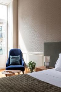 - une chambre avec un lit et une chaise bleue dans l'établissement Lit Apartments (2 Bedroom | City Center), à Porto