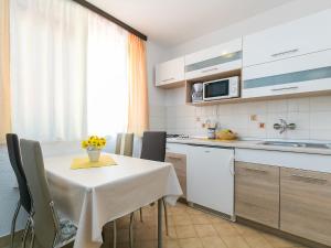 a kitchen with a table with chairs and a microwave at Apartment Vita in Poreč