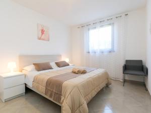 a bedroom with a large bed and a chair at Apartment Vita in Poreč