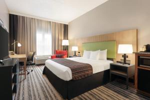 Country Inn & Suites by Radisson, Nashville Airport East, TN في ناشفيل: غرفه فندقيه سرير كبير وتلفزيون