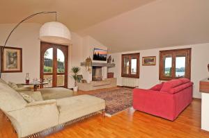 een woonkamer met 2 banken en een rode stoel bij VALLE FIORITA 42 - Lake view apartment in Gardone Riviera