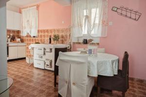 Selca的住宿－Apartments Jasna - peaceful area，一间厨房,内有粉红色的墙壁和一张桌子